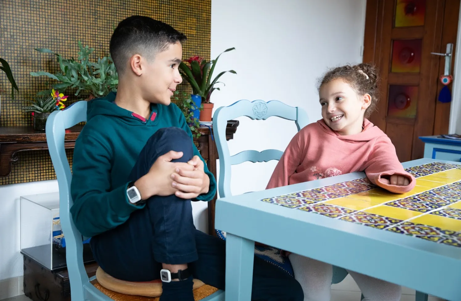 Child wearing Syde on ankle and wrist and talking to sibling