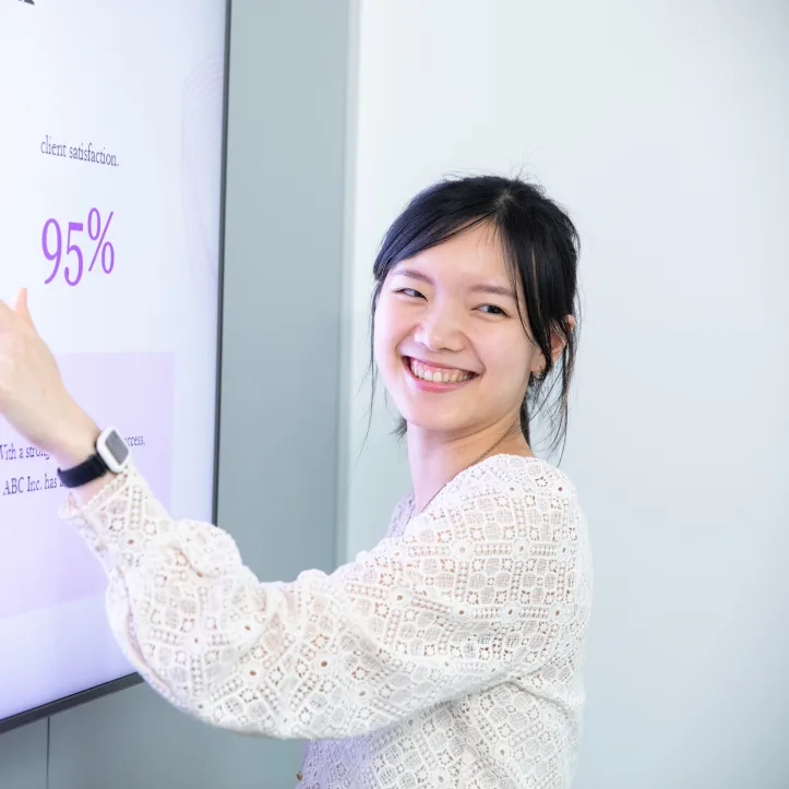 A woman wearing Syde wearable at work and presenting a powerpoint